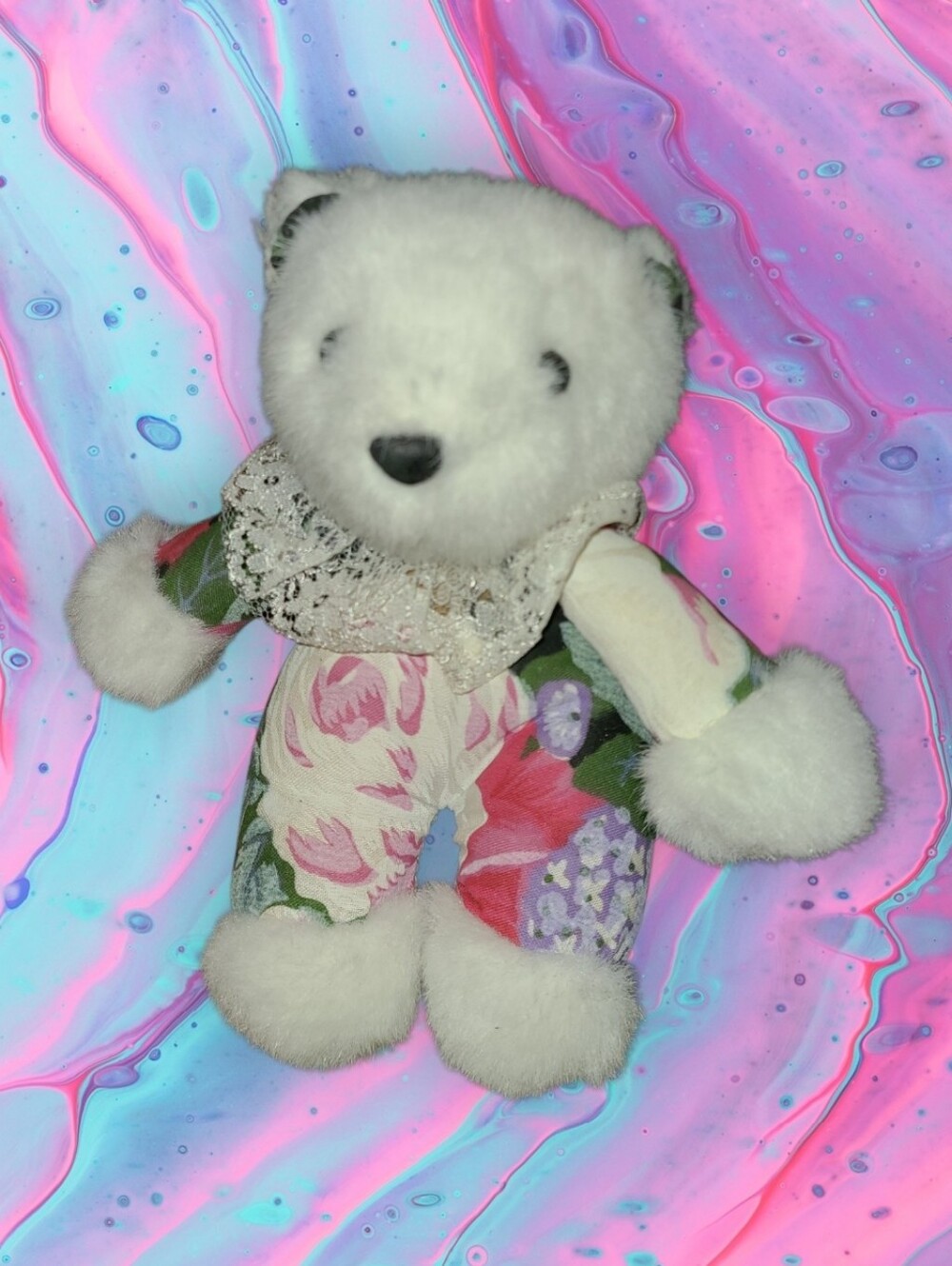 Vintage small teddy bear in floral outfit